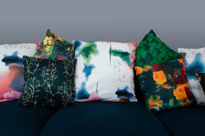 A display of Naruse Design cushions on a teal sofa with the forest green cushion at the centre back.