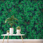 Forest explorer wallpaper captured in a room set with a white table and three potted plants. 