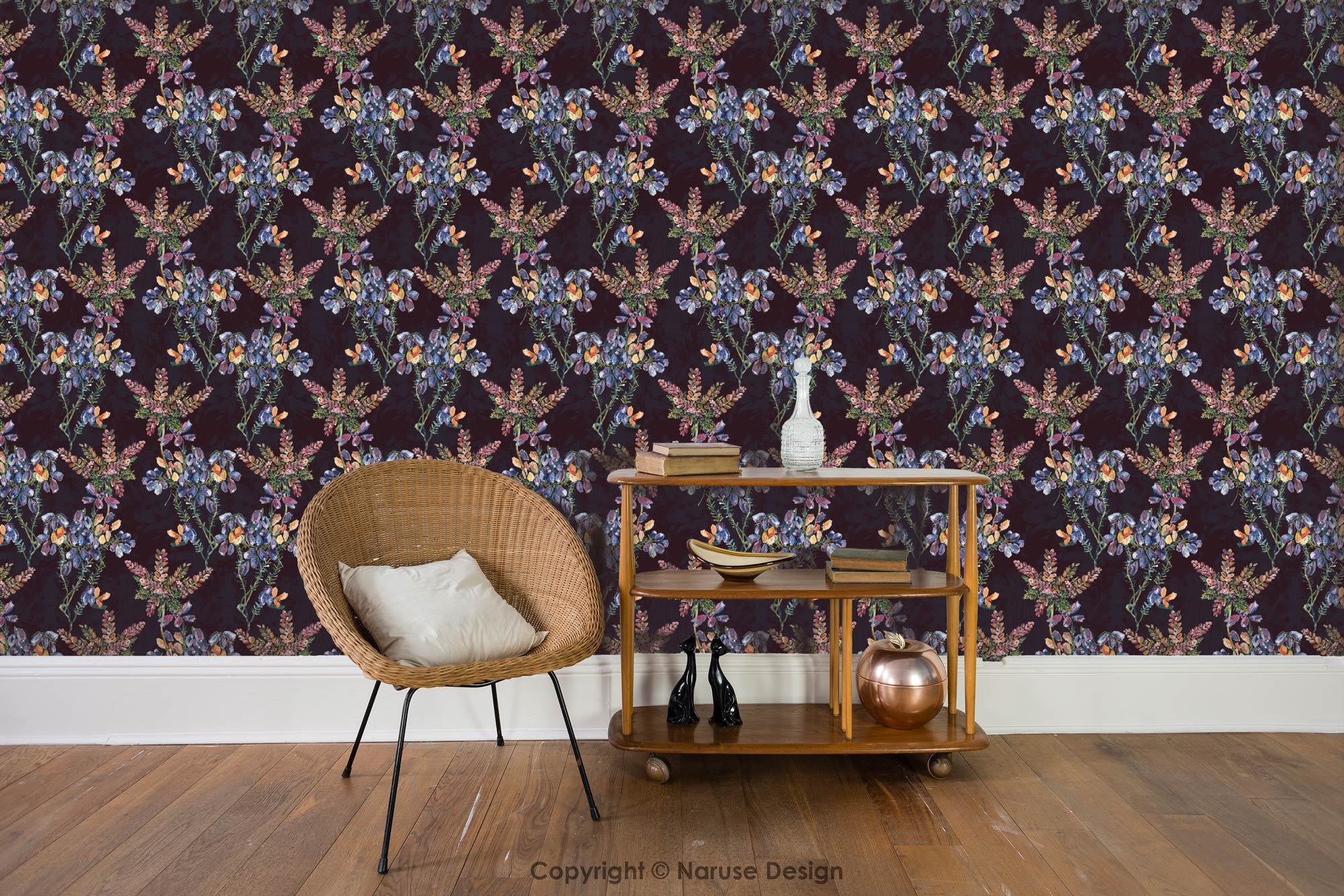 Wild heather wallpaper in the purple colourway representing on the wall of a modern living room with a woven chair and talbes with ornaments.