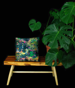 rock candy cushion on wooden table display next to cheeseplant