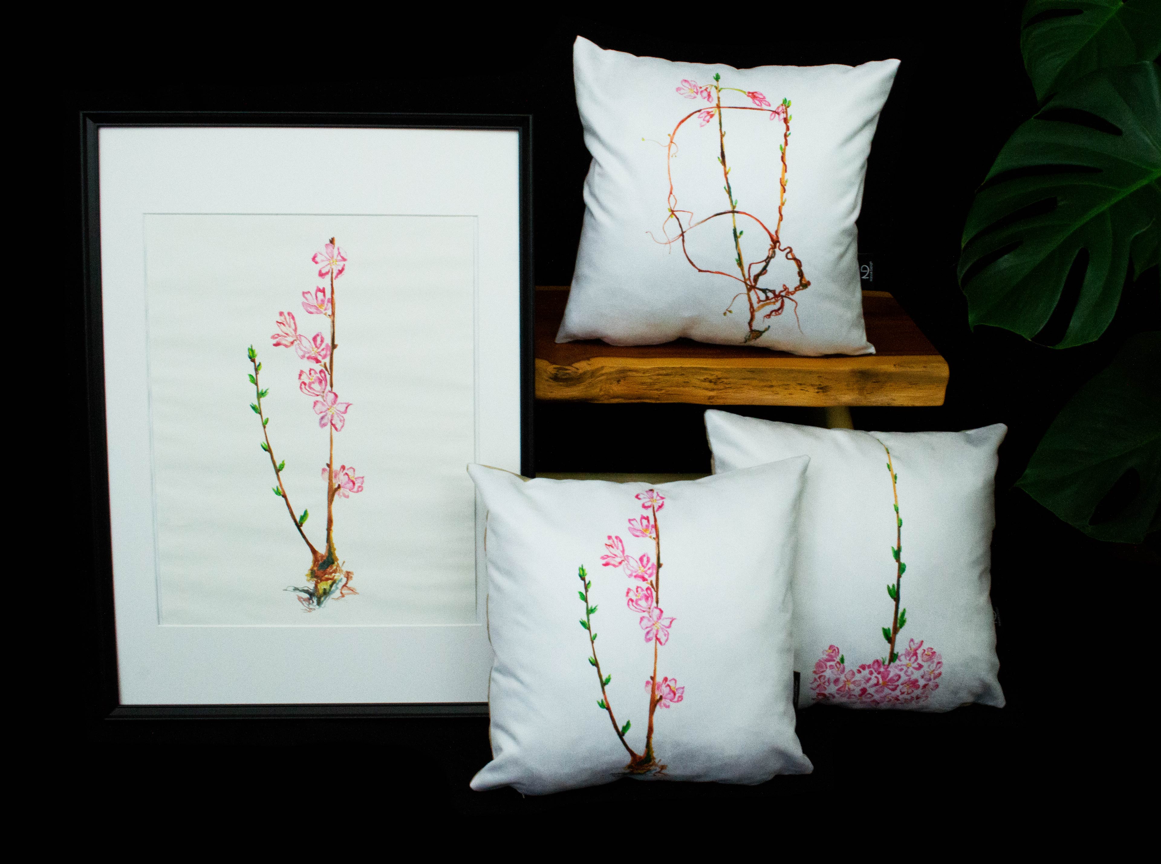 Sakura painting 3 framed displayed next to three sakura cushions.