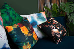 a collection of naruse design cushions displayed on a teal sofa including the summer burst cushion at the front