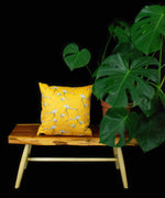 Tsuru cushion with small pattern displayed on wooden table next to a cheeseplant with a black backdrop